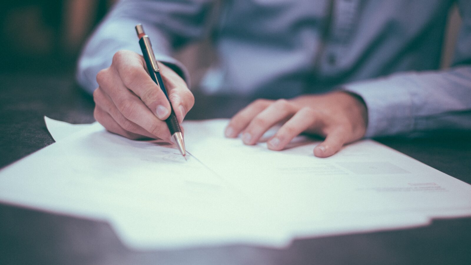 Person signing document representing the importance of an employment contract