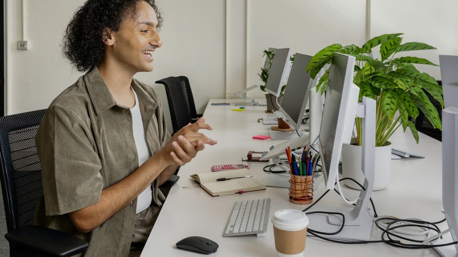 A worker at a long desk full of remote work computer stations, representing independent contractors in Ontario