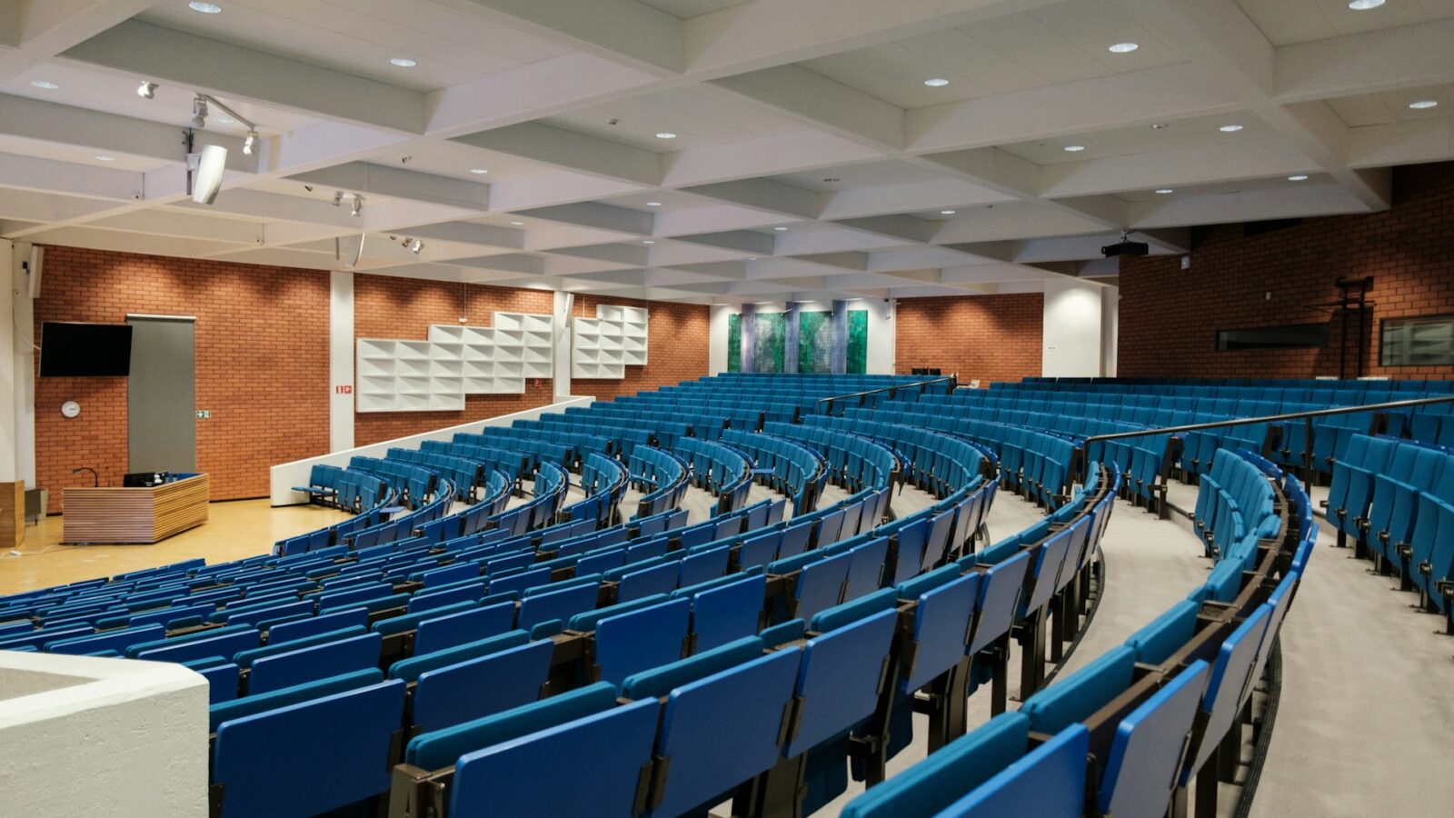 Rows of folded blue chairs in an university auditorium, representing student loans and spousal support.