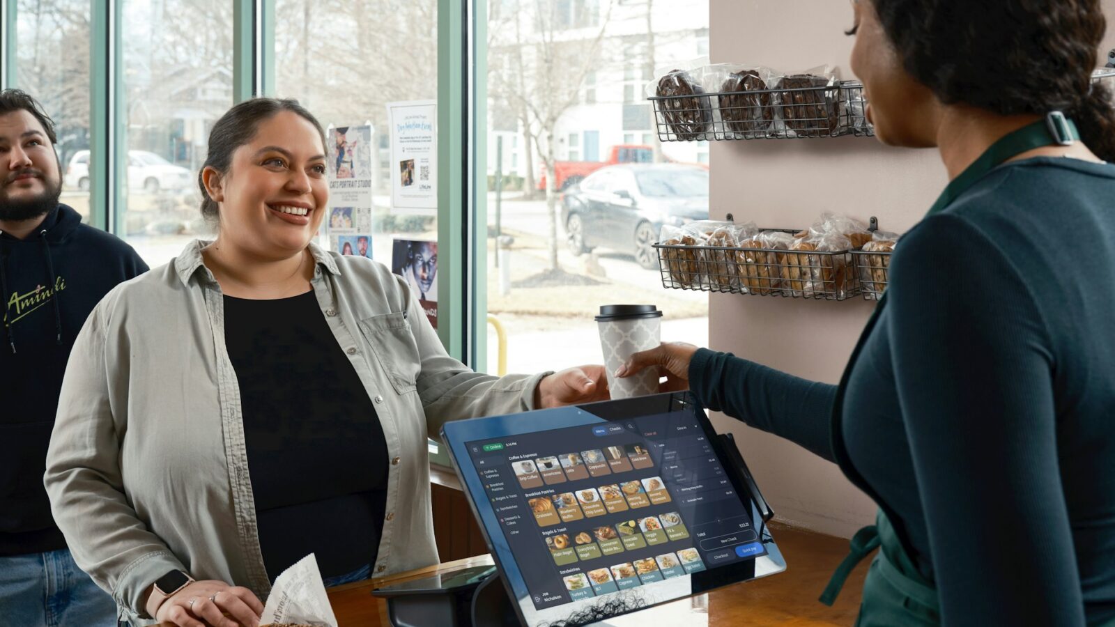 A woman buying a pastry at a small business cafe, representing Alberta business purchases and sales by earn-outs.