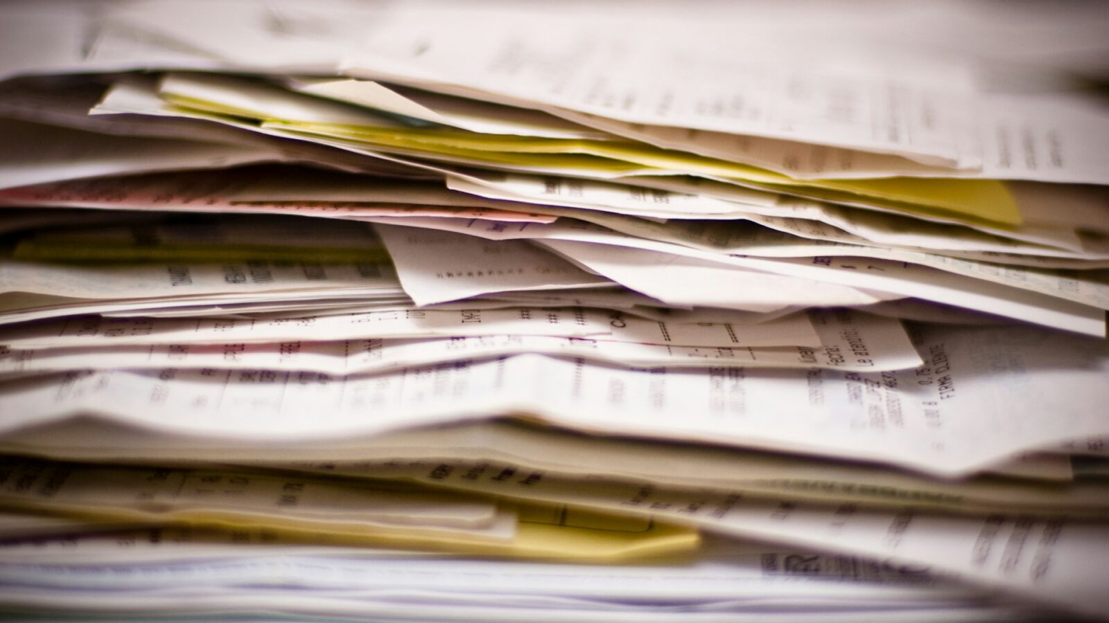 A close-up of a stack of wrinkled paper documents, representing missing estate assets in Alberta.
