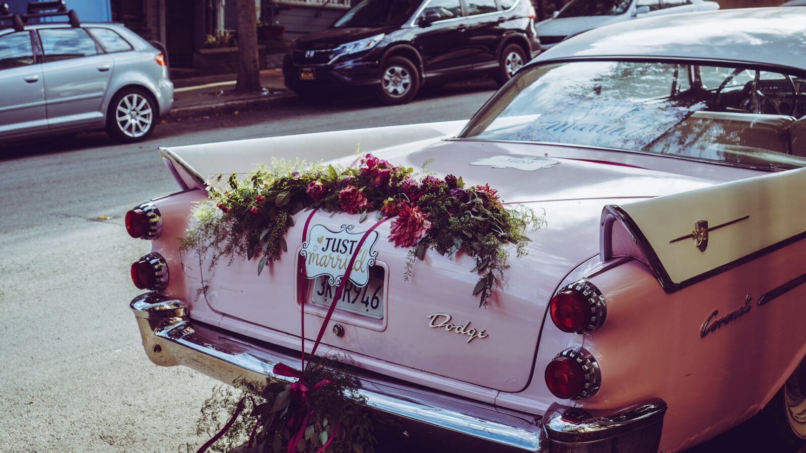 Pink wedding flowers and a "Just Married" sign on the back of a pink Cadillac, representing DIY prenuptial agreements in Alberta family law.